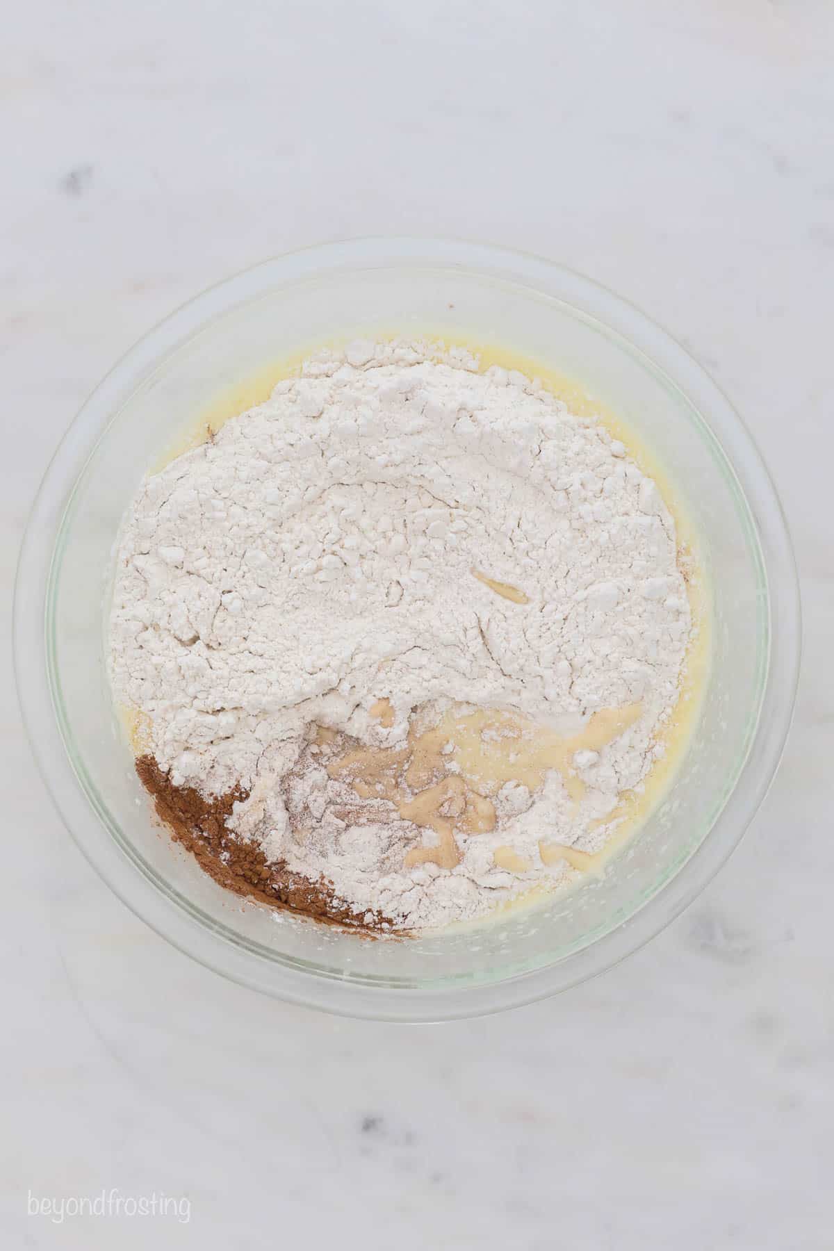 a glass mixing bowl with dry ingredients for