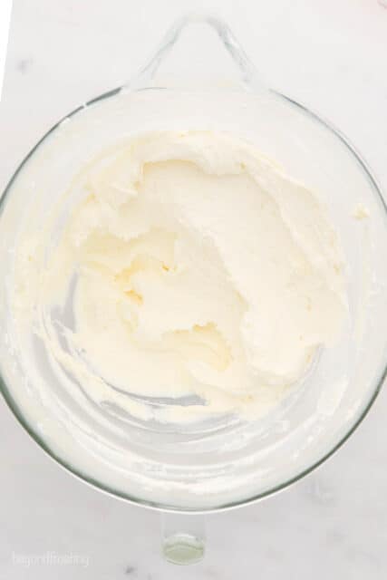 A glass mixing bowl with creamed butter and cream cheese