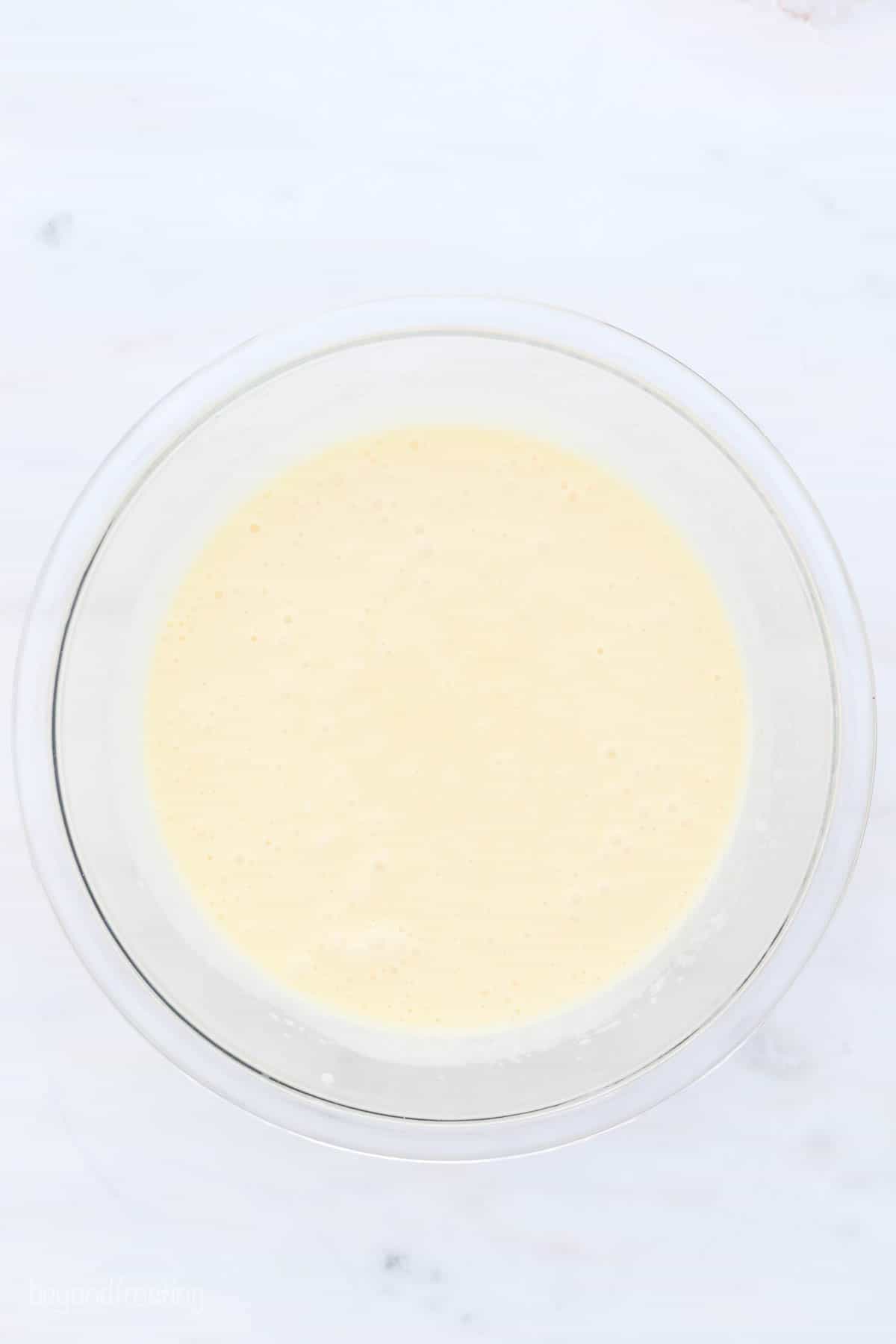 a glass mixing bowl with vanilla cupcake batter