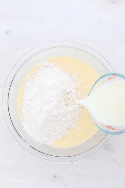 milk and flour in a glass mixing bowl for vanilla cake batter