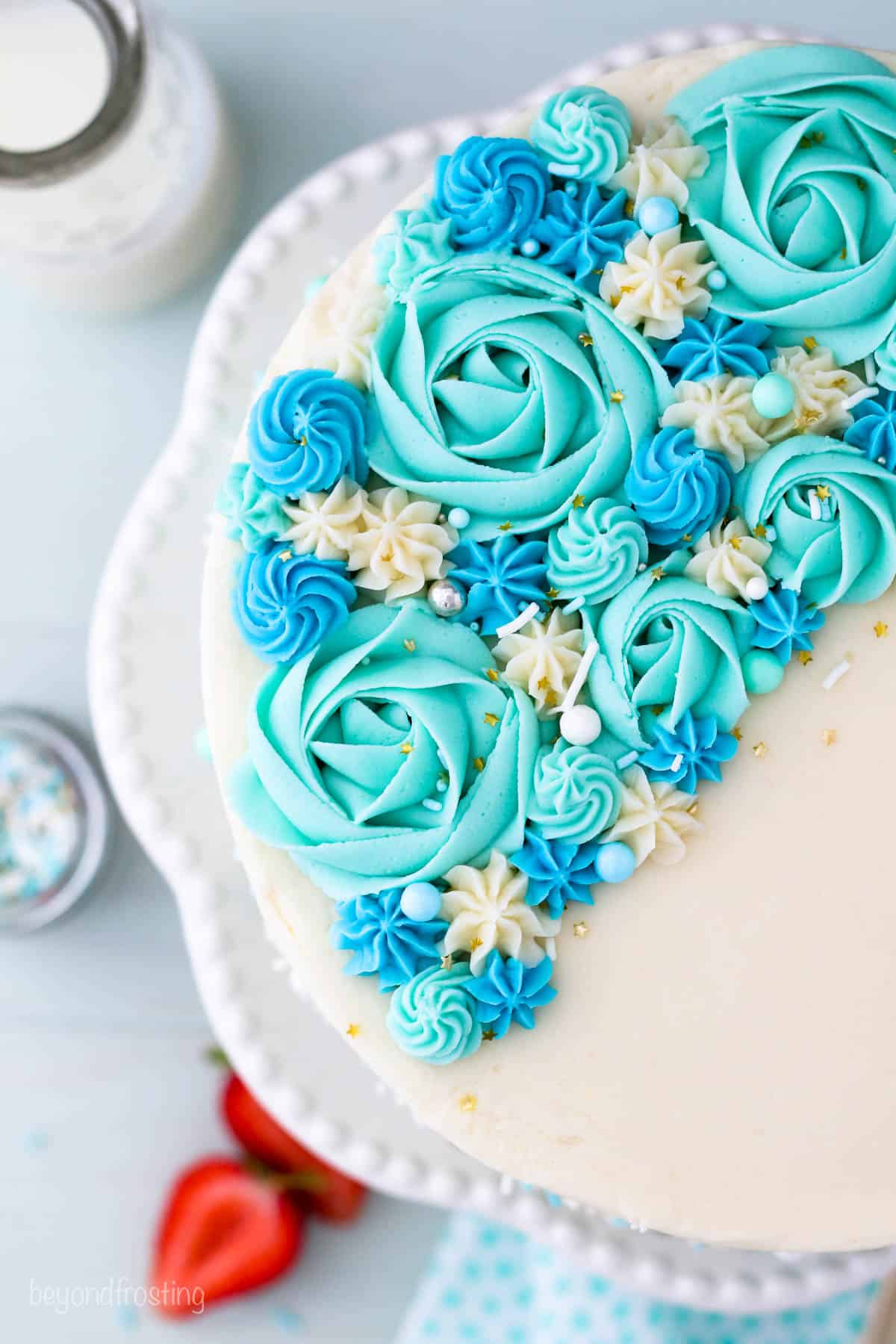 Overhead view of a cake decorated with blue and teal roses