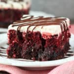 A close-up shot of a piece of red velvet brownie poke cake