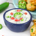 closeup of a blue bowl filled with jalapeño cheddar cheese dip