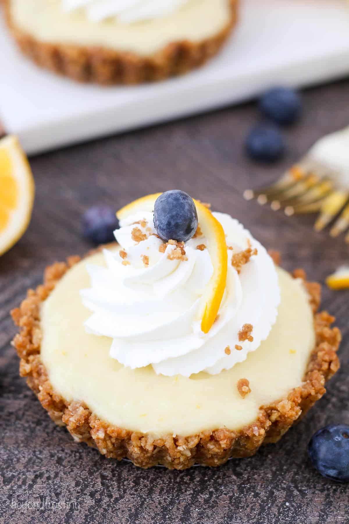 overhead of lemon pudding tart garnished with a blueberry