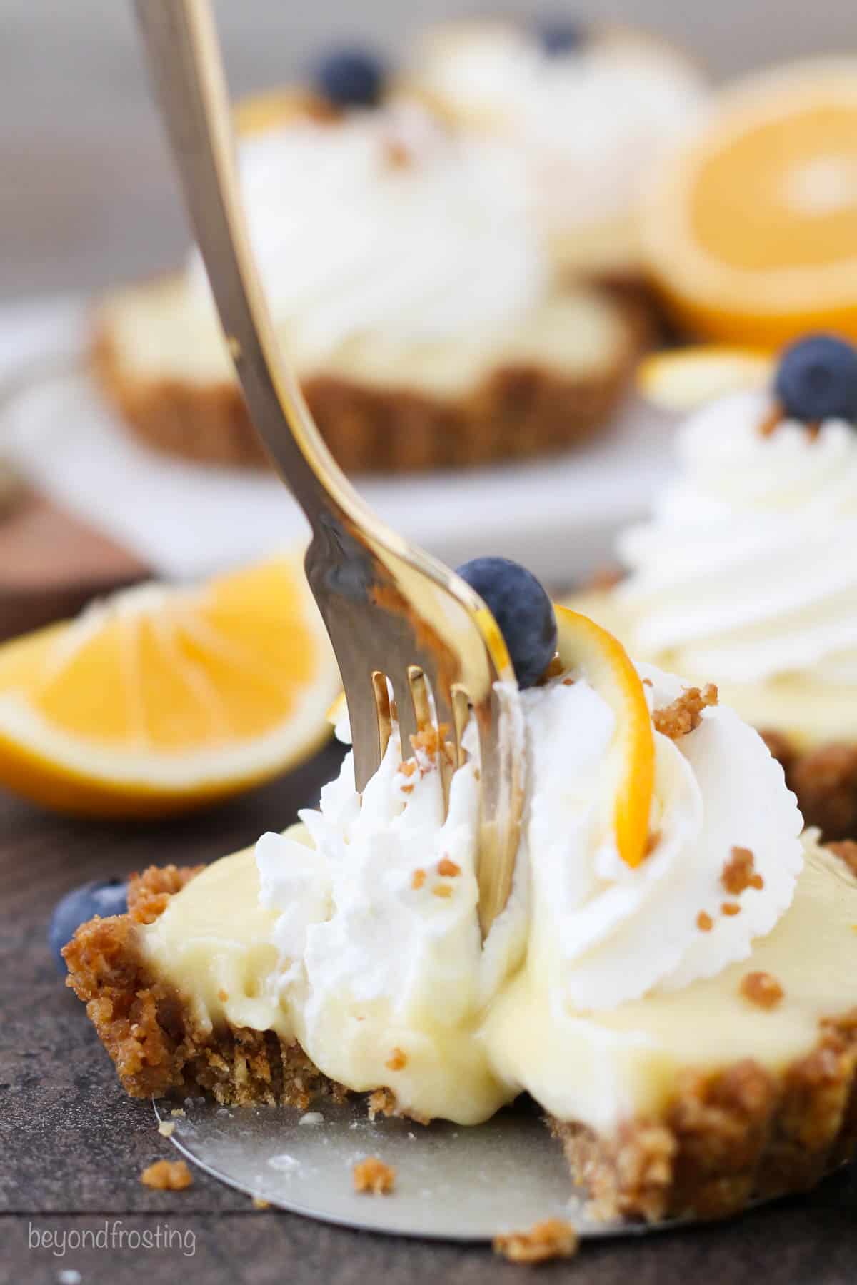 fork being used to take bites out of lemon pudding tart