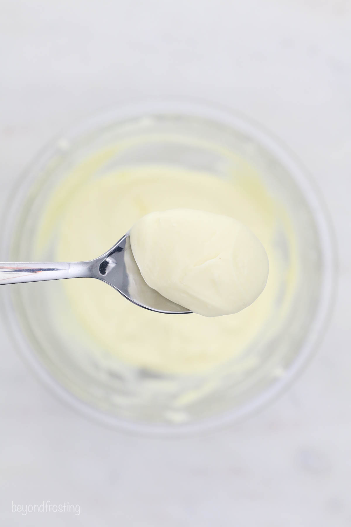 A spoonful of cheesecake filling for a cupcake