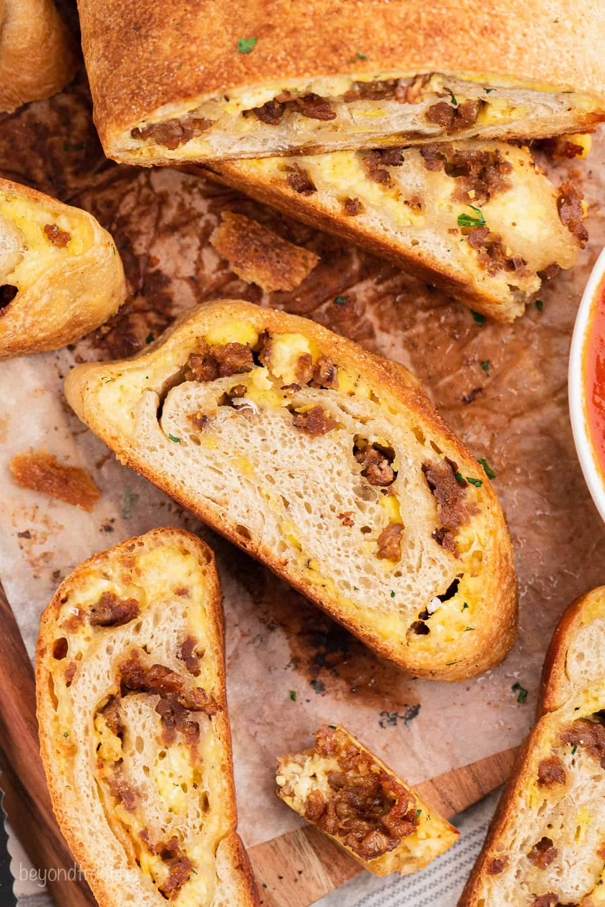 overhead of sausage bread slices on a cutting board