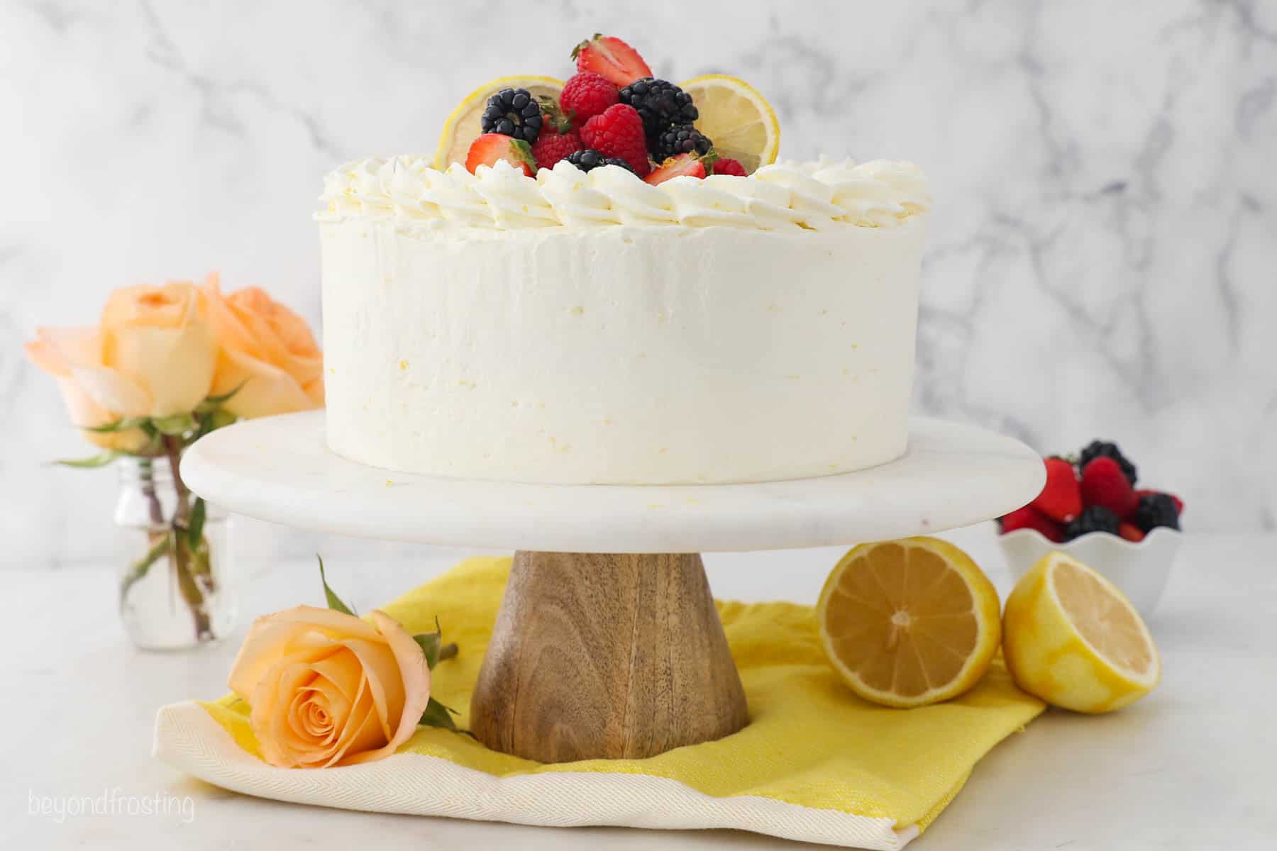 Decorated lemon layer cake with mascarpone frosting, topped with fresh fruit