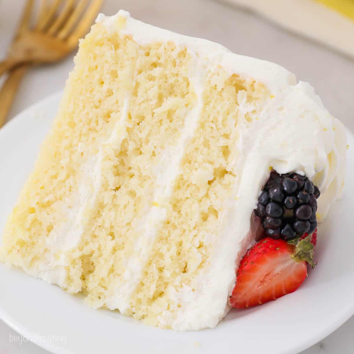 A slice of lemon layer cake on a white plate