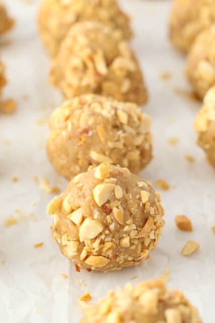 A peanut butter cookie dough ball rolled in crushed peanuts