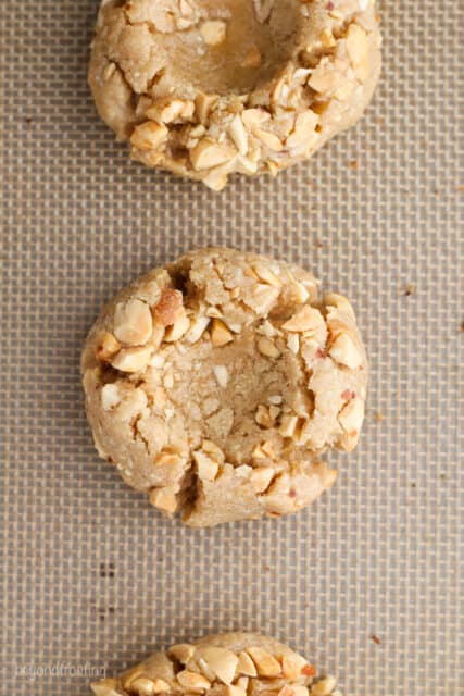 Overhead view of a peanut butter thumbprint cookie on a silicone baking mat