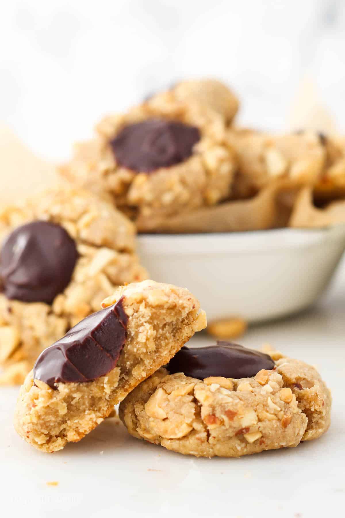 A peanut butter thumbprint cookie with a chocolate filling and a bite missing