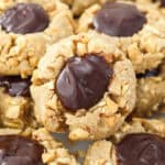 A close up of a peanut butter thumbprint cookie with a chocolate filling