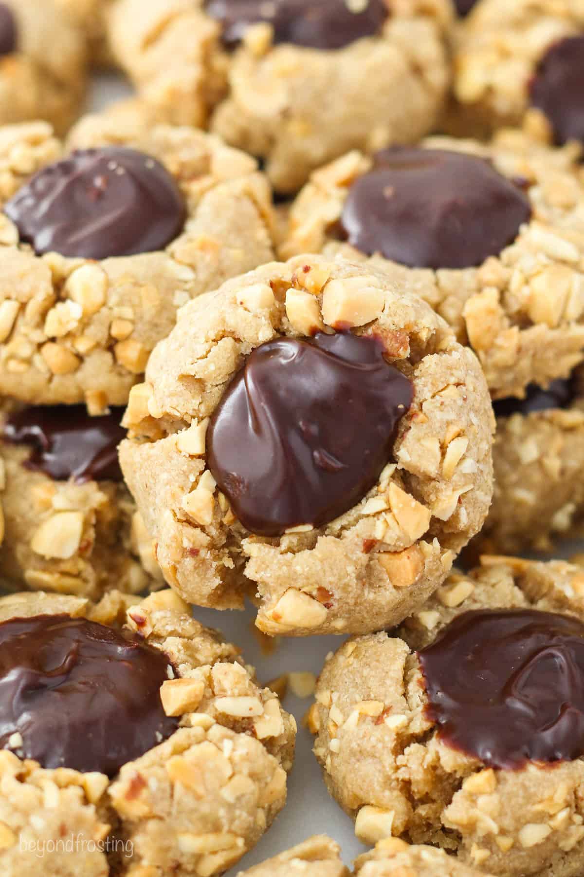 A close up of a peanut butter thumbprint cookie with a chocolate filling