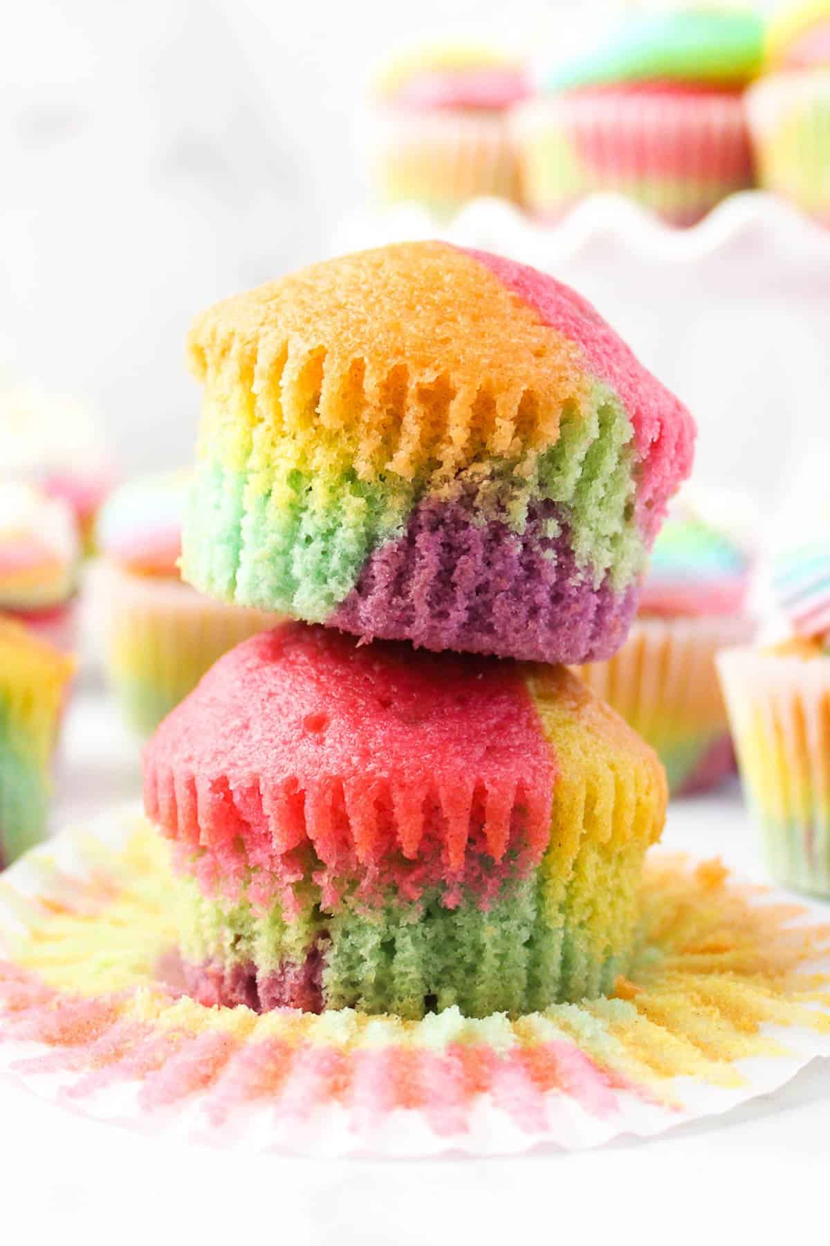 Two rainbow cupcakes stacked on top of each other