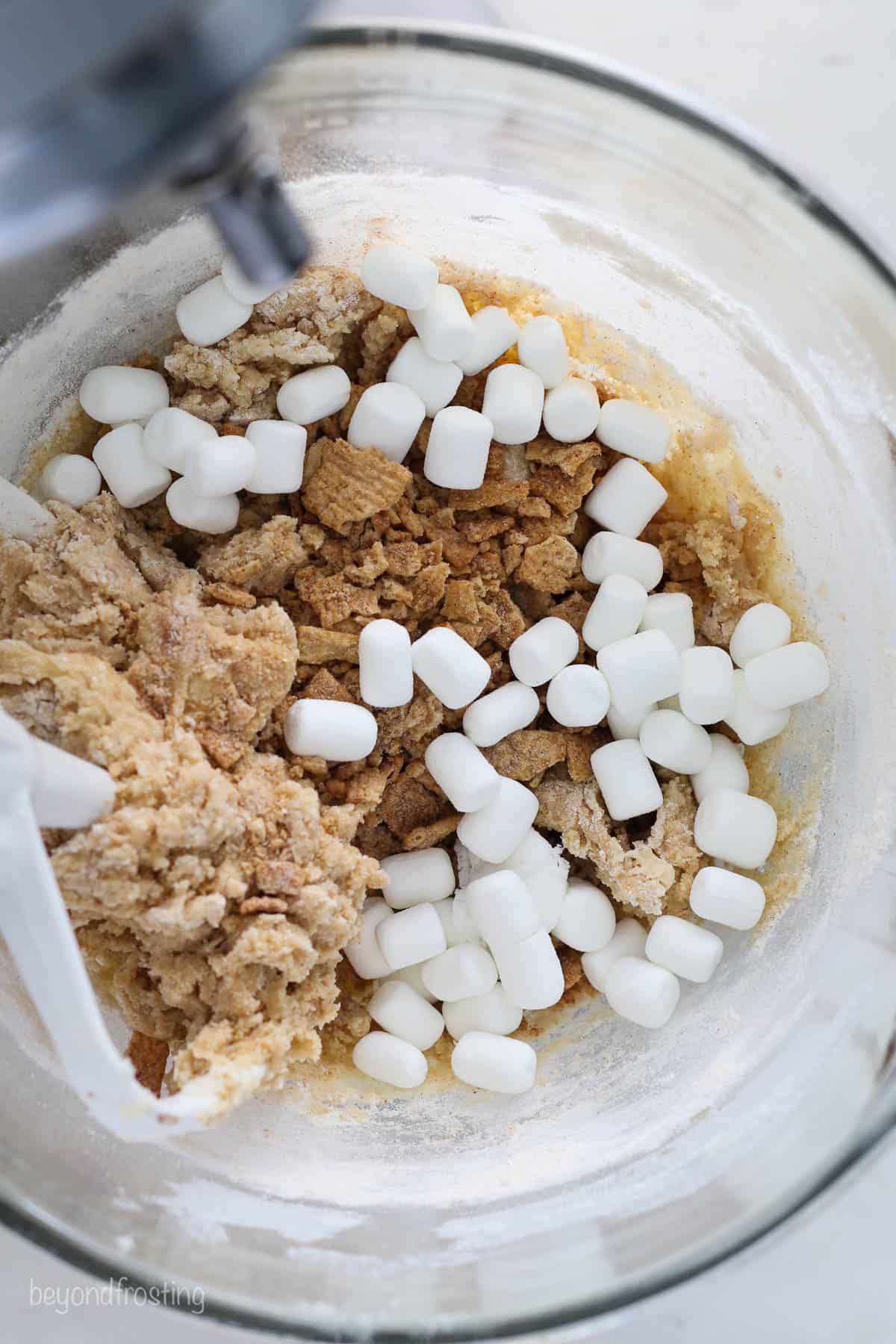 overhead of a bowl of cinnamon sugar cookie dough with marshmallows and Cinnamon Toast Crunch added