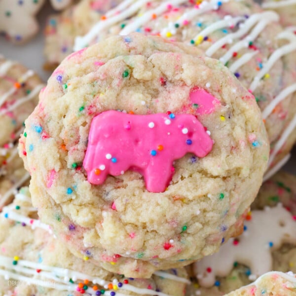 A close up of a sugar cookie with a pink Circus Animal Cookie in the middle