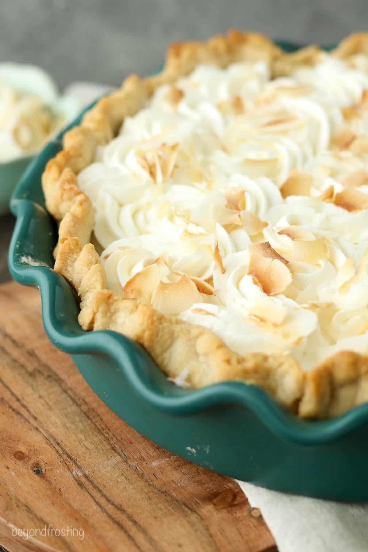 overhead of a finished coconut cream pie in a green baking pan