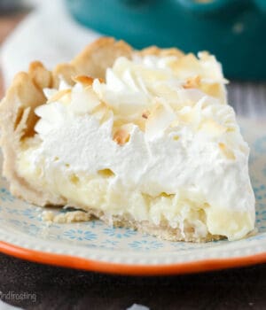 closeup of a slice of coconut cream pie on a plate with blue flowers