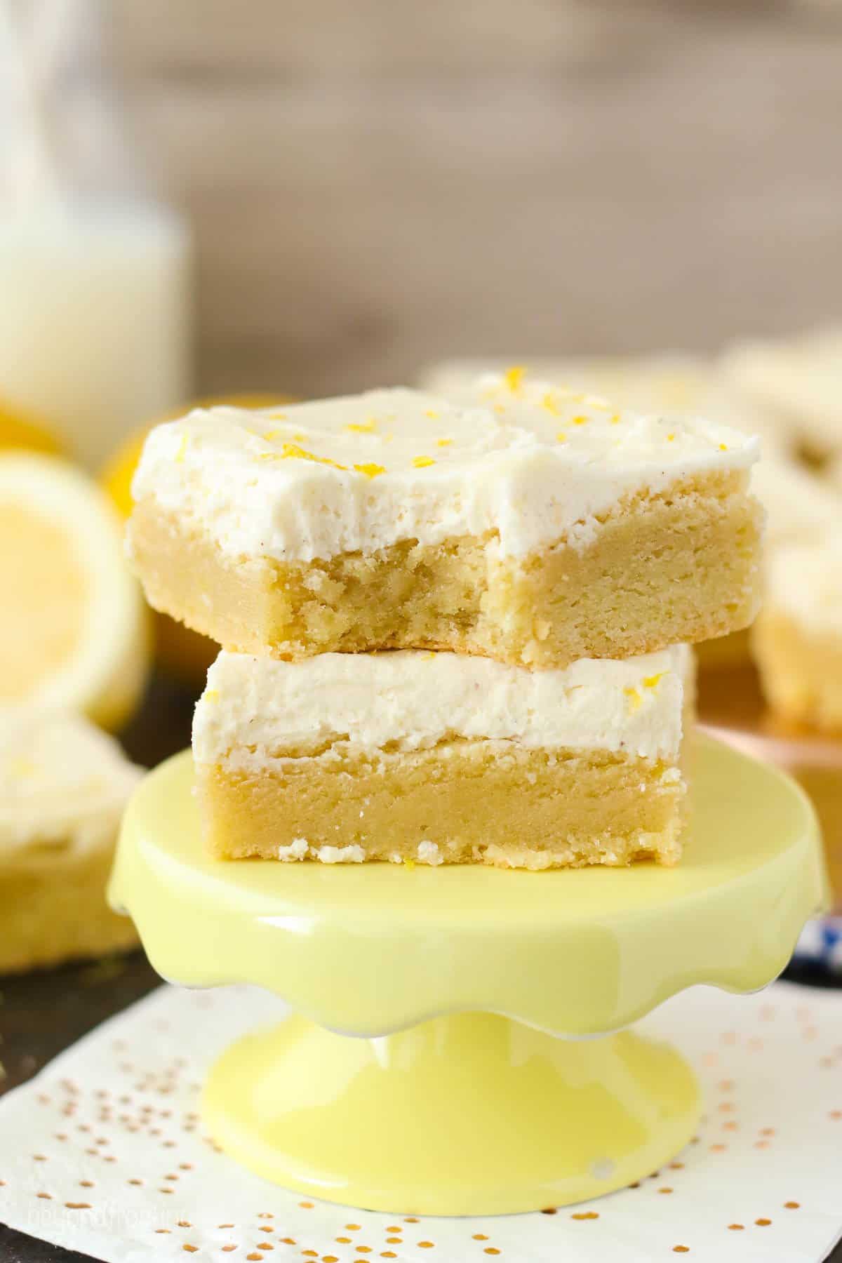 two lemon cookie bars on a yellow stand