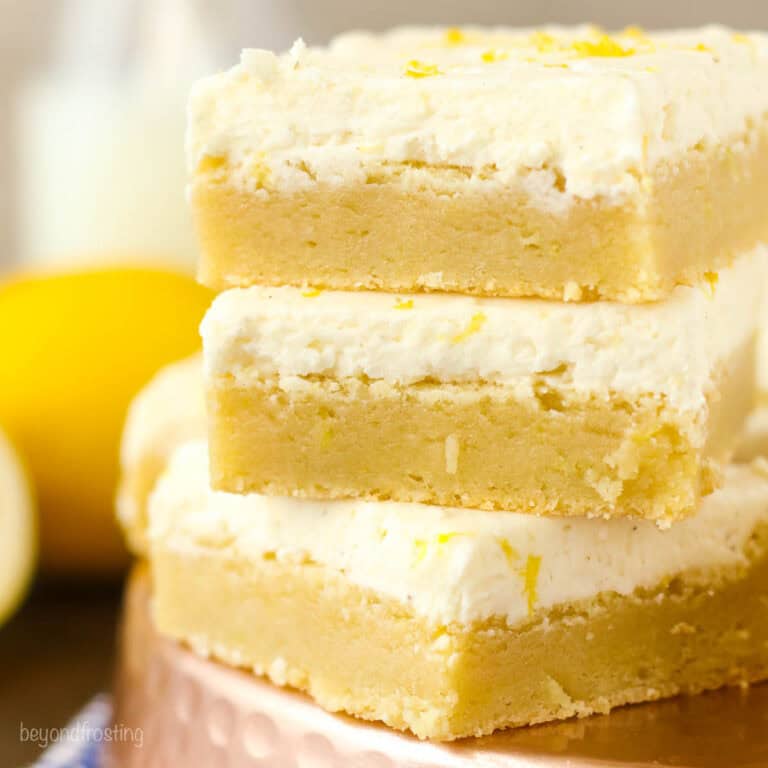 Closeup of three lemon sugar cookie bars stacked.