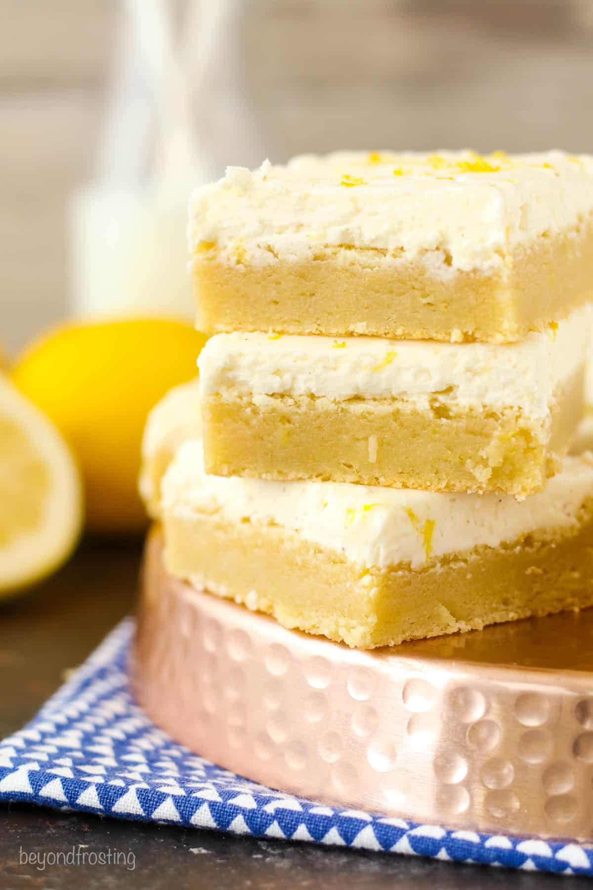 three lemon cookie bars stacked on a serving platter