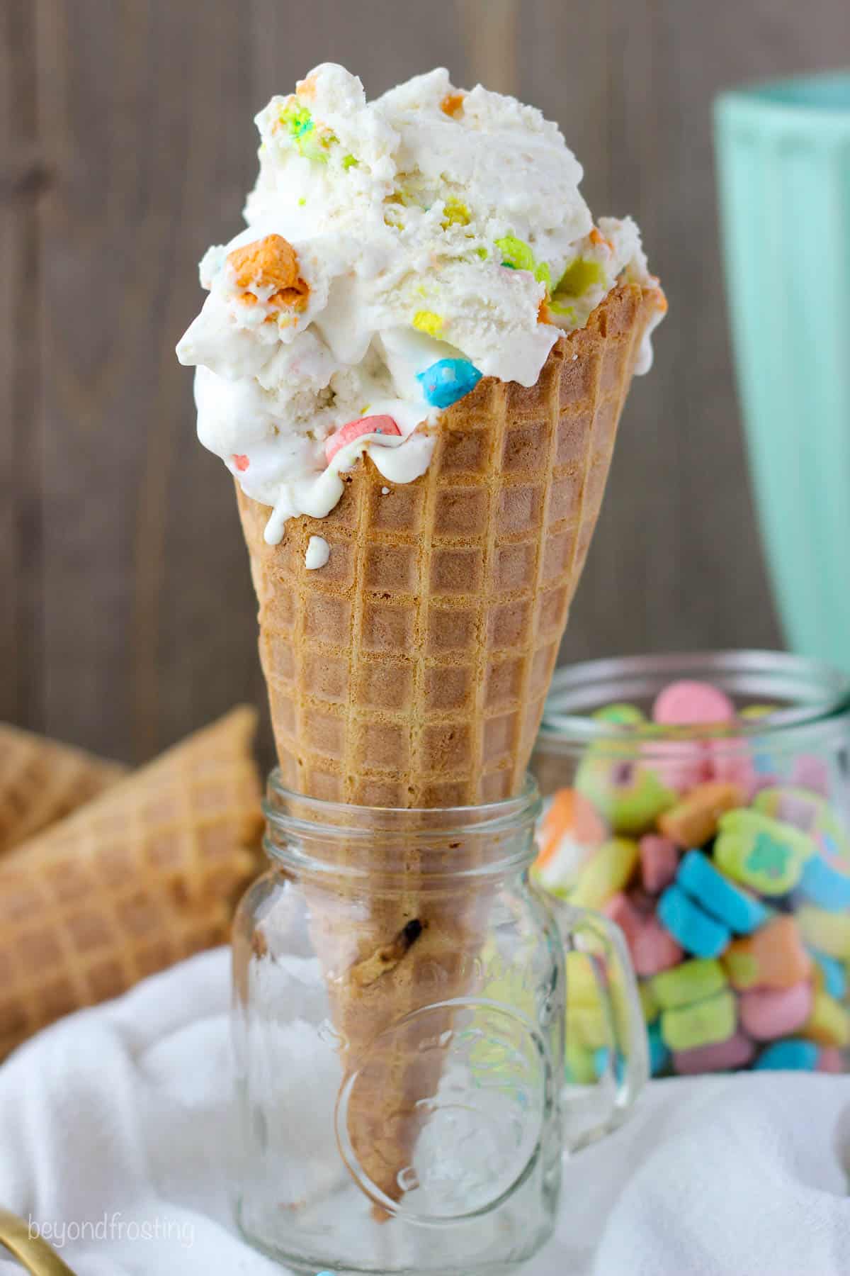 A scoop of Lucky charms ice cream in a waffle cone