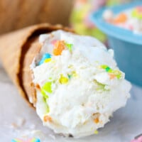 A close up of a scoop of Lucky charms ice cream in a cone