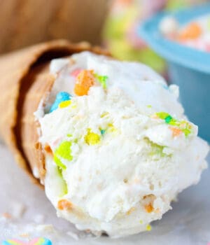 A close up of a scoop of Lucky charms ice cream in a cone