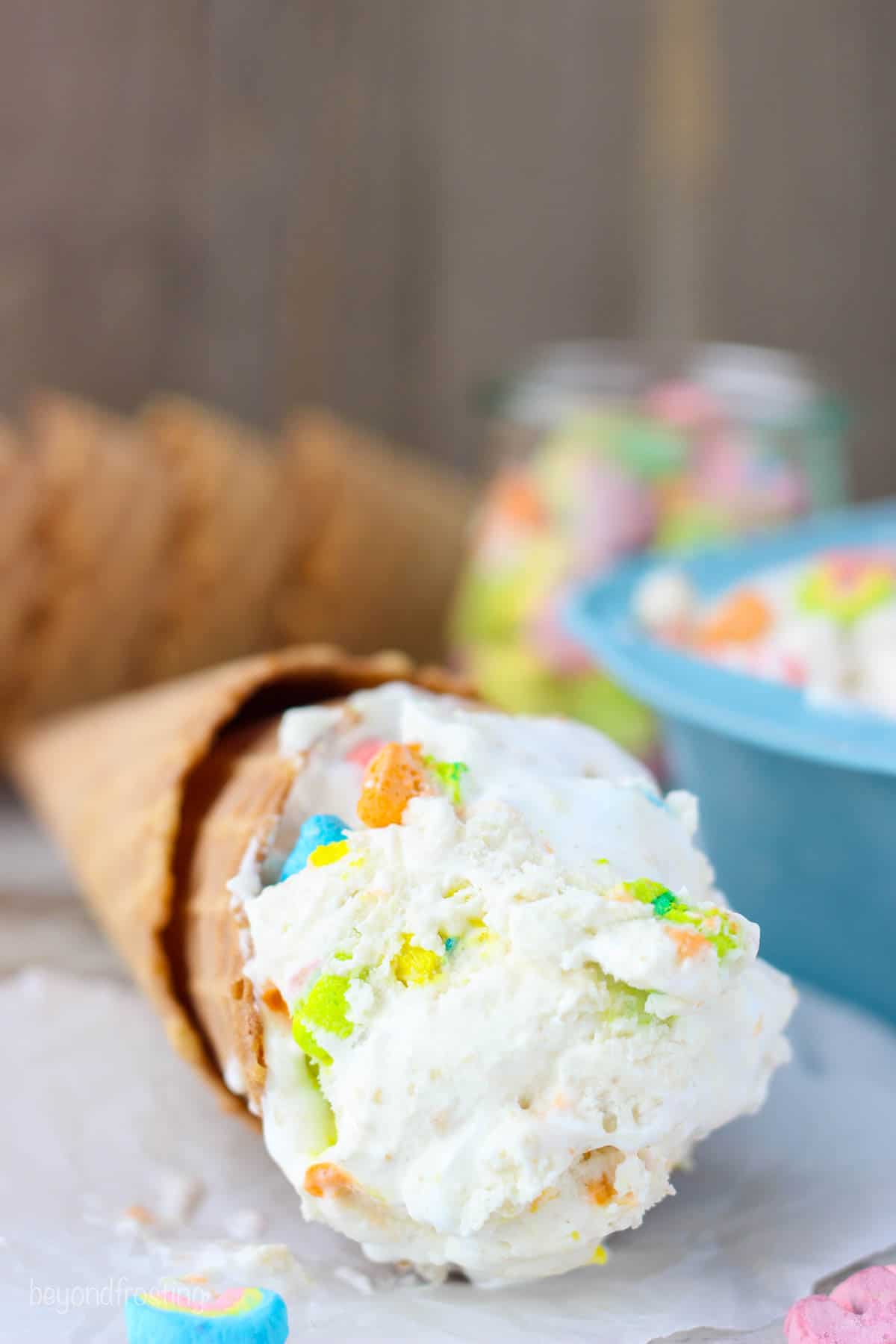 A scoop of Lucky charms ice cream in a cone