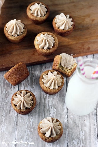 A bunch of snickerdoodle cookie cups scattered on a dining table with a jar of milk beside them