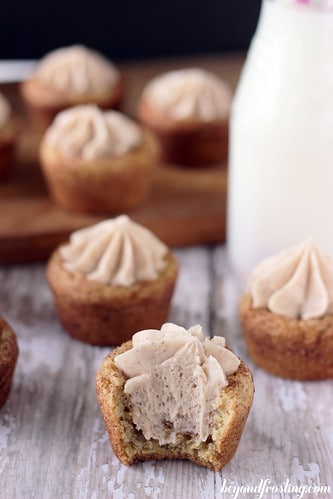 A maple cinnamon cookie cup with a bite taken out of it and more cookie cups behind it
