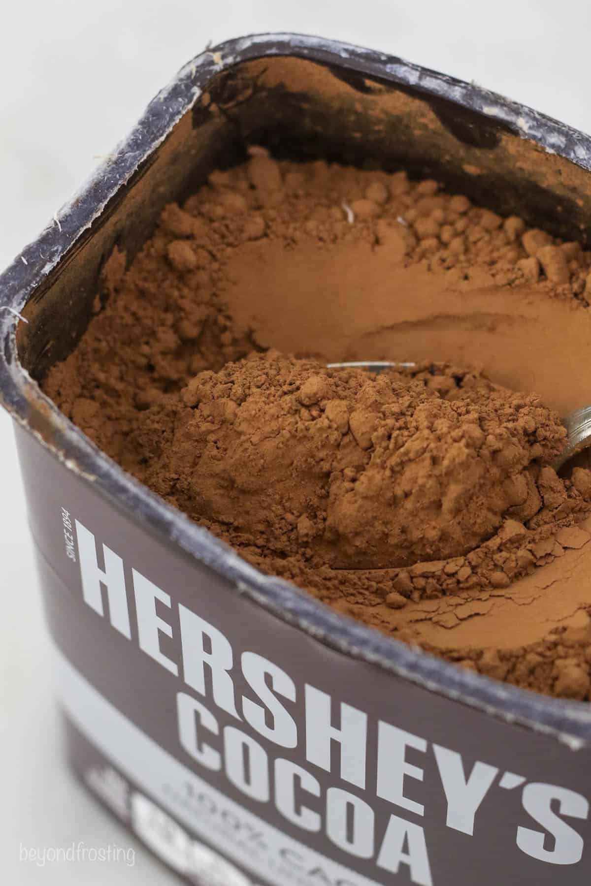an open jar of Hershey's Cocoa powder with a spoon in it