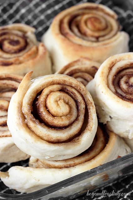 Overnight cinnamon rolls piled inside of a glass pan before any icing has been added