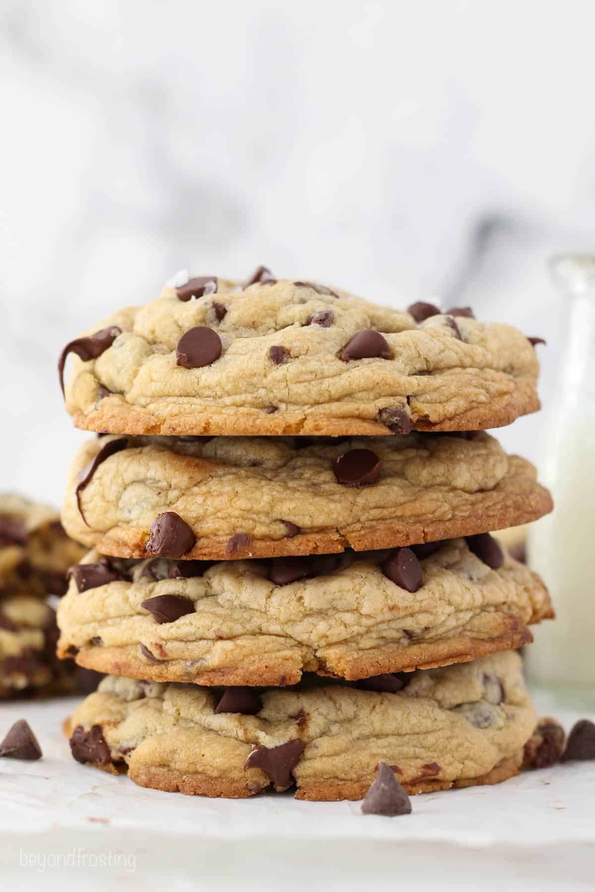 Four large thick chocolate chip cookies stacked on top of each other