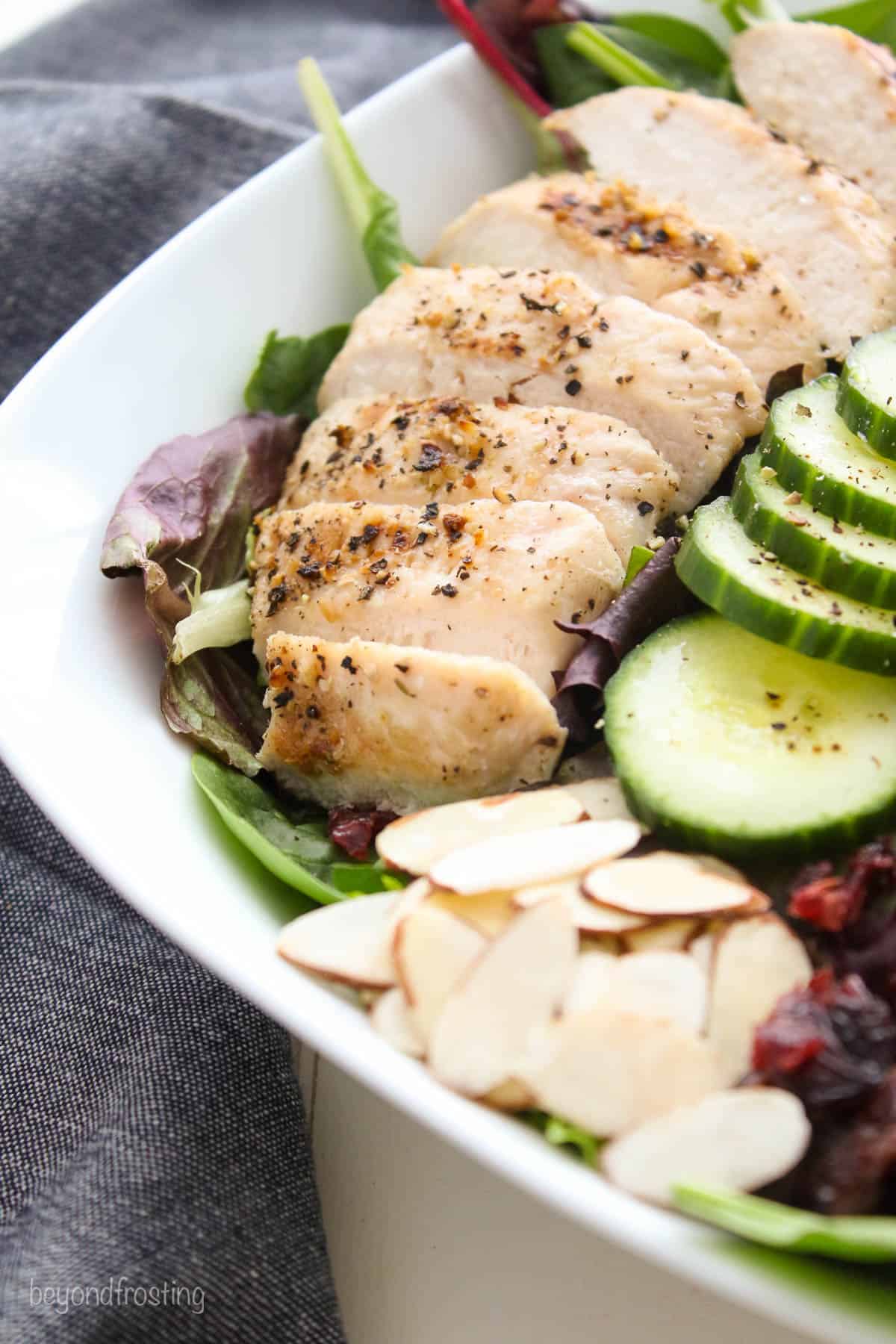 closeup of grilled chicken layered on a salad