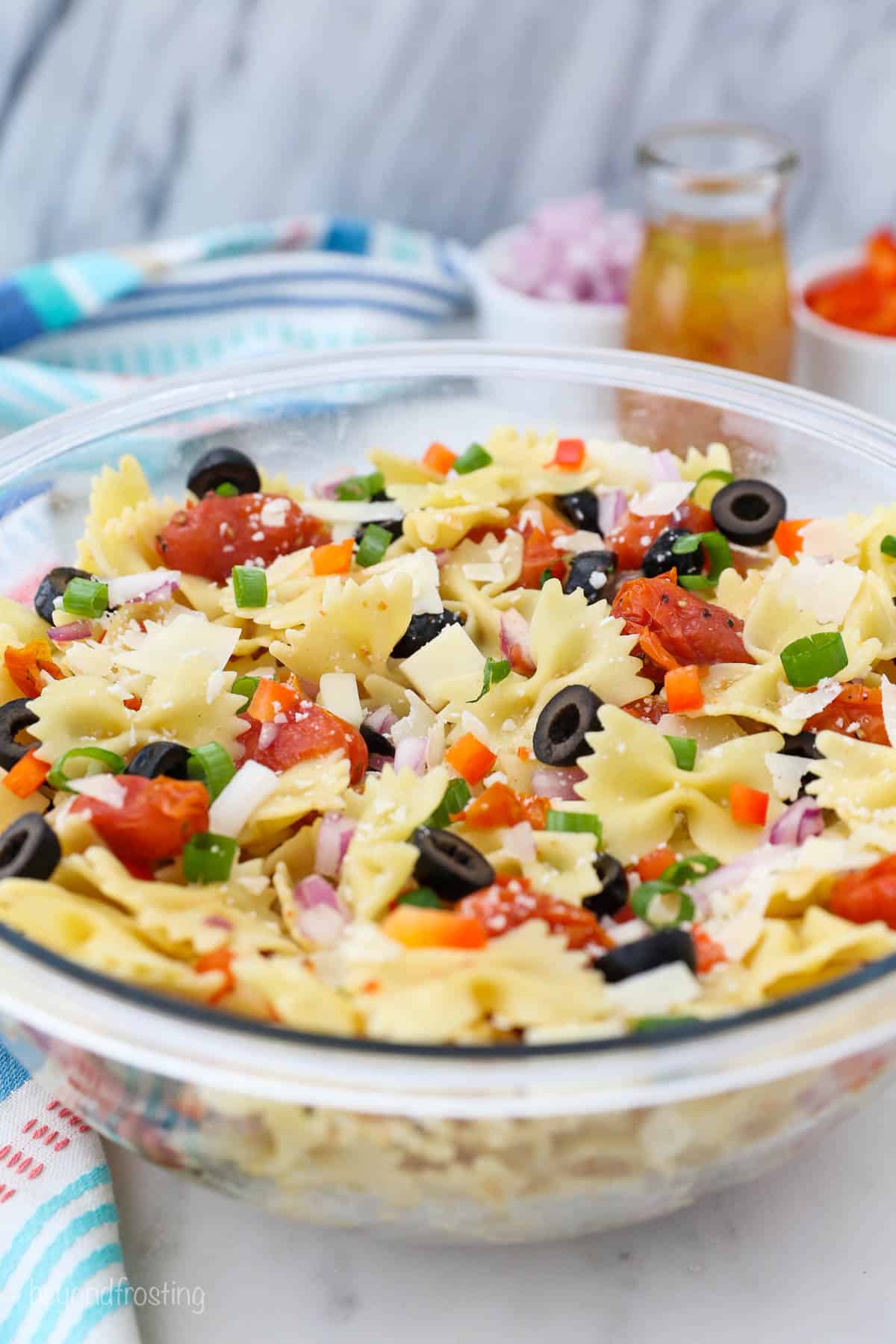 a large clear bowl full of pasta salad