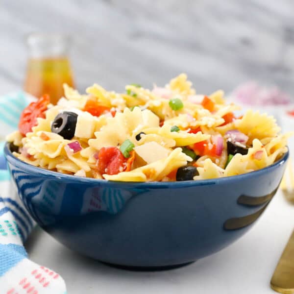 closeup of a blue bowl filled with summer pasta salad