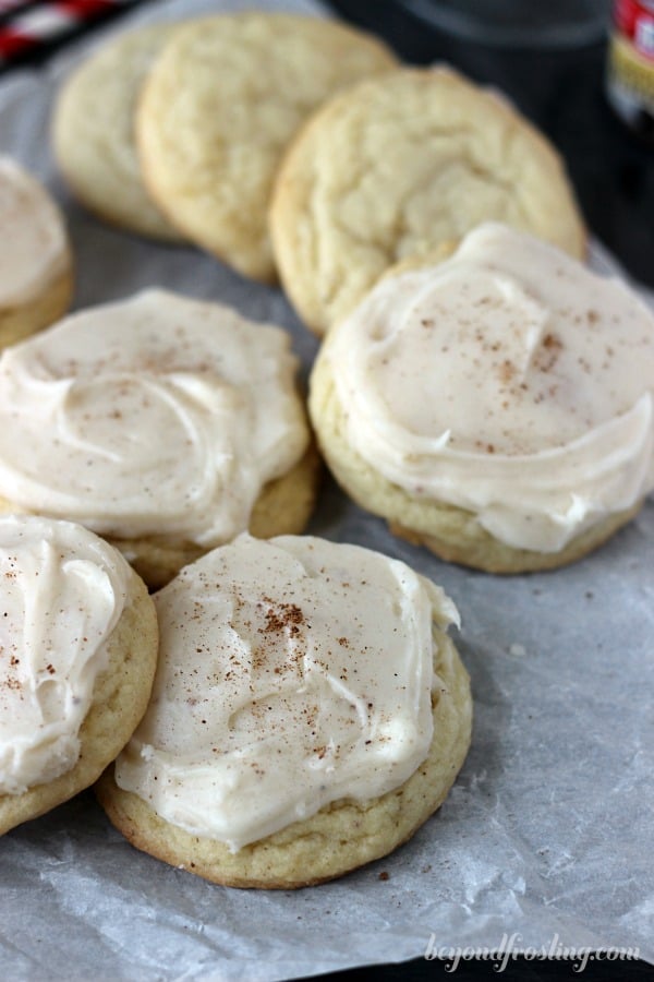 eggnog sugar cookies leaning on one another on a piece of parchment paper