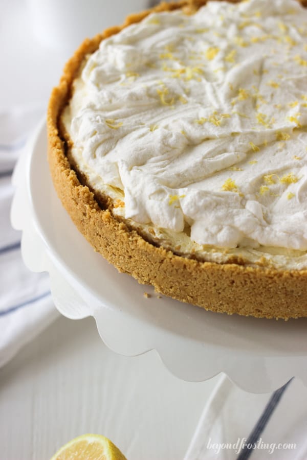 overhead of a whole lemon ice cream pie on a cake stand
