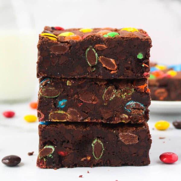 Three M&M brownies stacked on top of one another.