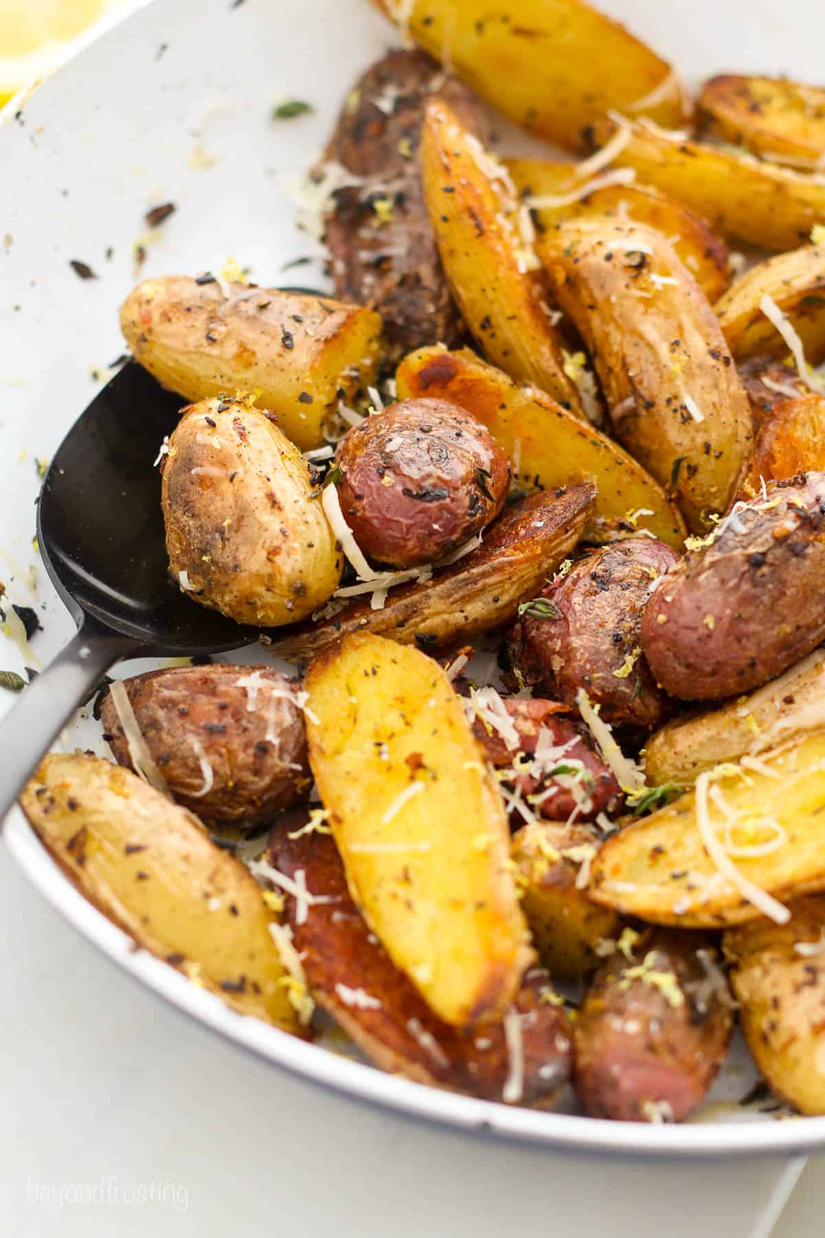 roasted potatoes on a plate garnished with grated parmesan