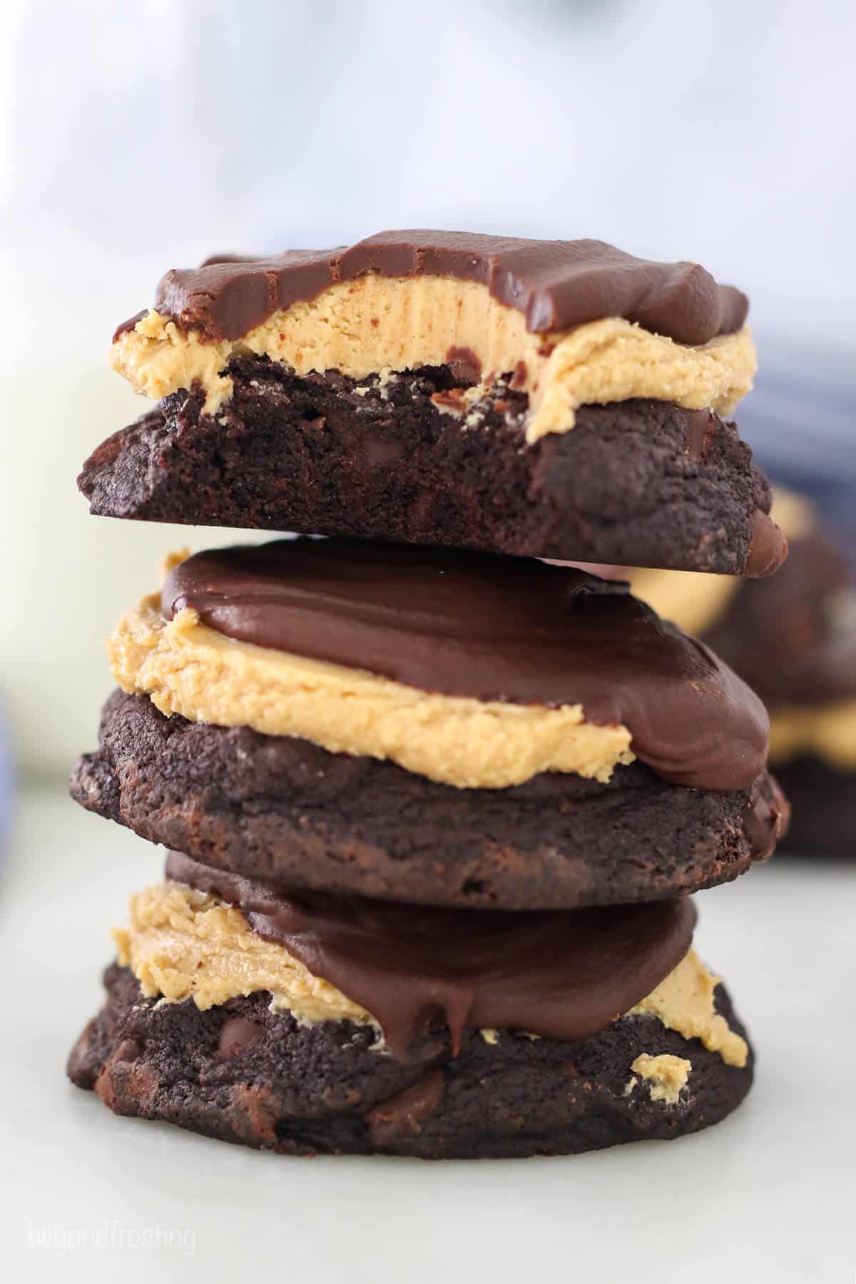 A stack of 3 peanut butter buckeye cookies, the topped with a bite missing