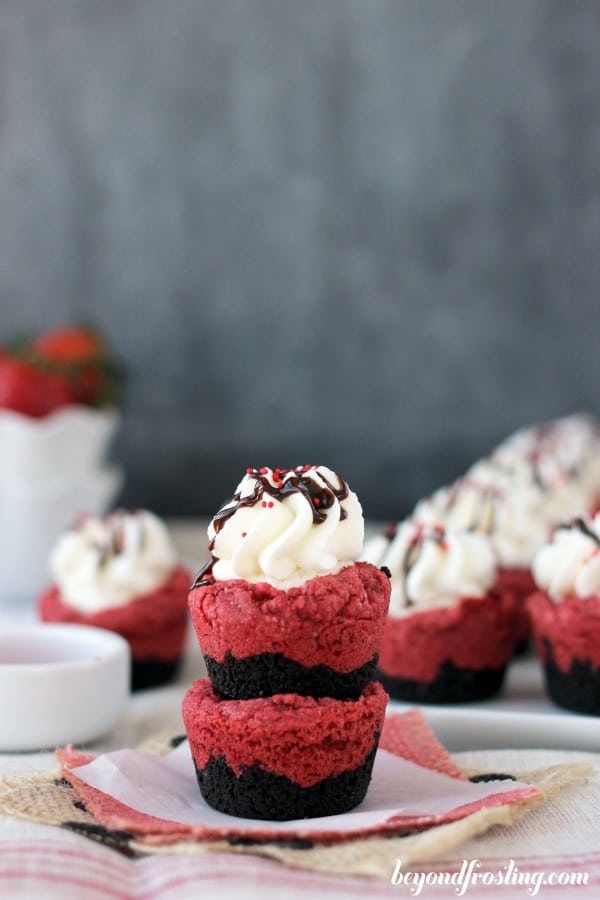 two red velvet cream pie cookie cups stacked with more in the background