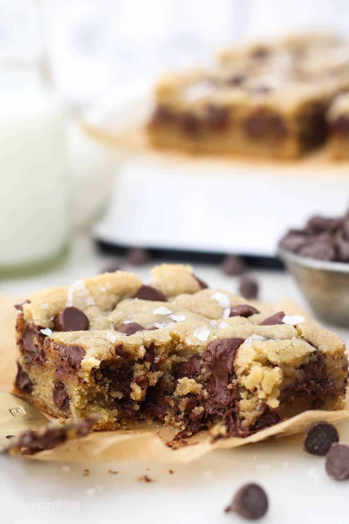 Angled view of a chocolate chip cookie bar with a bite missing