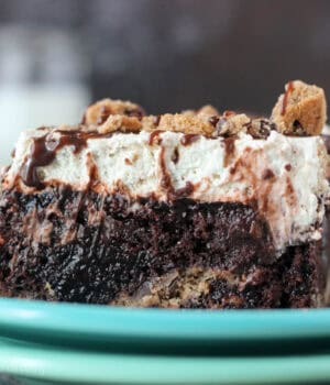 closeup of a slice of chocolate poke cake on a blue plate