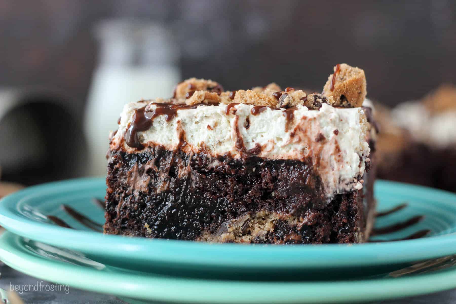 side view of a slice of chocolate poke cake on two stacked plates