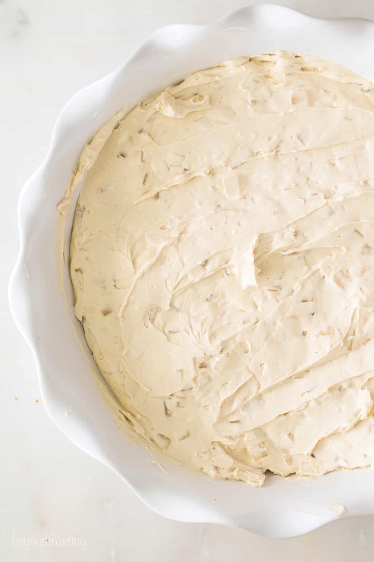 The cream cheese base for cold crab dip in a pie dish