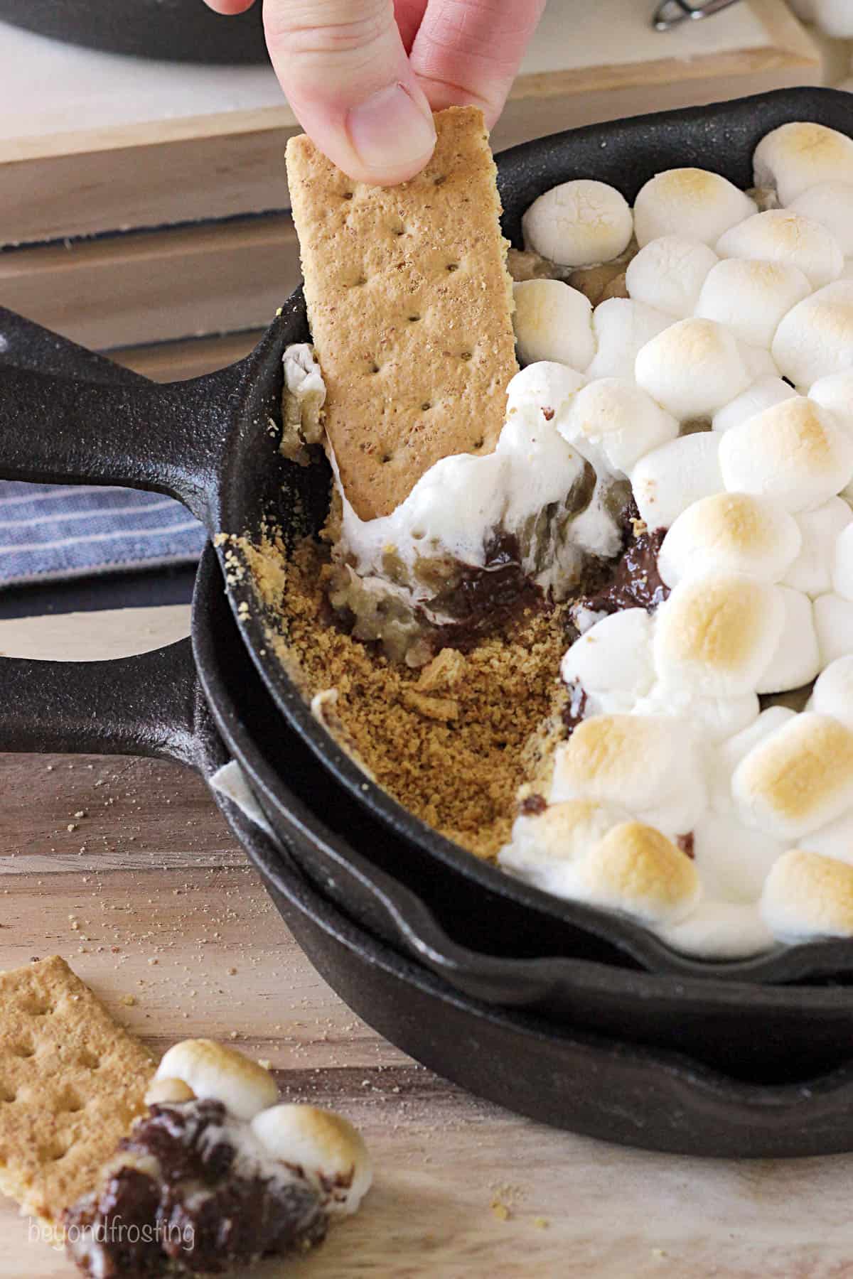 overhead of s'mores dip being scooped up with a graham cracker