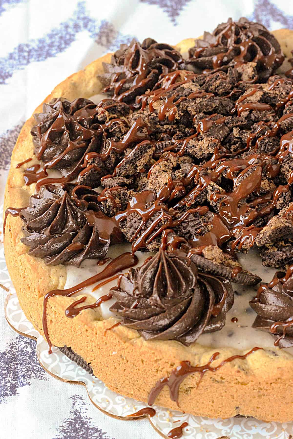 overhead of a whole cookies and cream cookie cake drizzled with melted chocolate